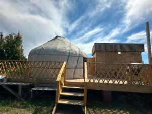 a yurt with a wooden deck and a ladder at Nomads Home in Tong +5 photos
