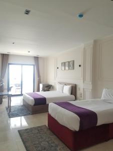 a hotel room with two beds and a window at Nile Castle in Luxor +52 photos