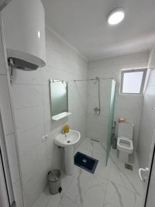 a white bathroom with a sink and a toilet at Apartments Gzim Peja in Ulcinj +22 photos
