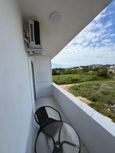 a balcony with a chair and a window with a spider on it at Apartments Gzim Peja in Ulcinj
