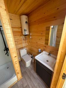 a bathroom with a toilet and a sink and a tub at Nomads Home in Tong