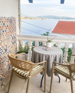 a table and chairs on a balcony with a view of the water at Saint Sunday in Kamenari