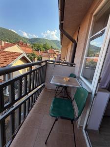 a balcony with a table and chairs and a view at Apartmani Erdeljanov in Soko Banja