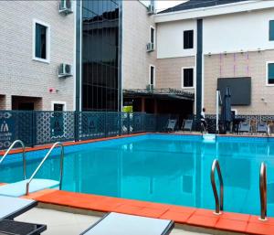 a swimming pool in front of a building at Movela Hotels in Warri
