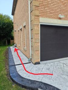 a red hose on a sidewalk next to a garage at New and Stylish 3BR Private Basement Apartment with 3 Baths & Parking in Richmond Hill