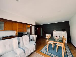 a living room with a couch and a table at Descanso, Mar & Conforto in Esposende
