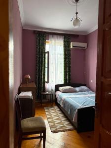 a bedroom with a bed and a window and a chair at Maryams Studio Guesthouse in Zugdidi