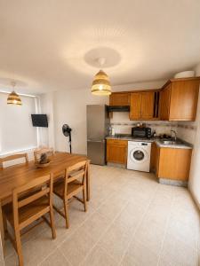 a kitchen with a wooden table and a stove top oven at El HierroStay Appartments - La Chalana & El Remo in La Restinga +28 photos