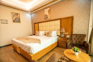 HAMDAN Hotel في هرجيسا: غرفة نوم بها سرير وكرسي وطاولة