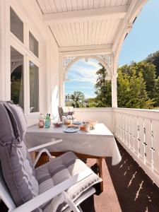 a white porch with a table and chairs on it at Villa Victoria in Binz