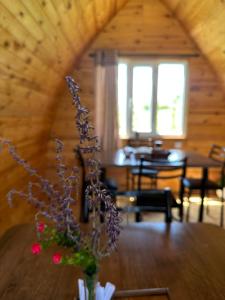 a living room with a table with a vase of flowers at Nomads Home in Tong