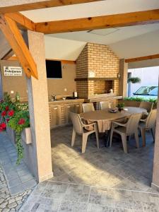 a patio with a table and chairs and a kitchen at Apartmani Erdeljanov in Soko Banja