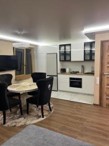 a kitchen and living room with a table and chairs at Ritos Namai in Druskininkai