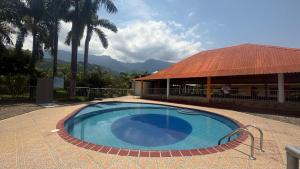 a swimming pool in front of a house with a building at Finca Las Marias A&M in Restrepo