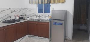 a kitchen with a refrigerator and a sink at Belle vue in Aïn Draham +7 photos