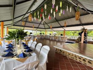 a tent with a table and white chairs and a woman at Finca Las Marias A&M in Restrepo