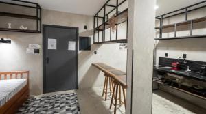 a small kitchen with a table and a bed in a room at FLAT PALLADIUM - de frente in São Vicente