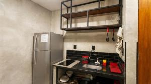 a small kitchen with a sink and a refrigerator at FLAT PALLADIUM - de frente in São Vicente