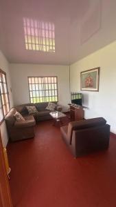a living room with couches and a table and windows at Finca Las Marias A&M in Restrepo
