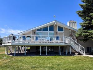 a large house with a deck and chairs on it at Bear Lake Ranch with Bear Lake Access in Garden City