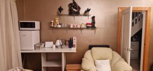 a room with a table and a chair and a microwave at Coastal Harmony B&B in Portstewart