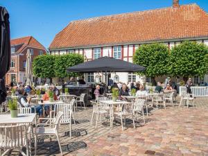 a group of people sitting at tables and chairs in front of a building at Charming Retreat near Attractions - By Traum Ferienwohnungen in Ringkøbing