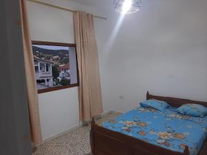 a bedroom with a bed and a large window at Belle vue in Aïn Draham