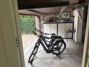 a bike parked in a garage next to a door at Fiddler's Hoorn in Zwaag
