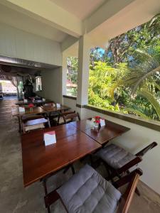 a restaurant with tables and chairs and a large window at Pousada e Chocolateria Muito Mais in Itaparica
