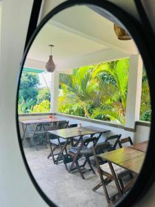 a reflection of tables and chairs in a mirror at Pousada e Chocolateria Muito Mais in Itaparica