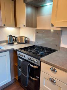 a kitchen with a stove top oven in a kitchen at Sandytoes and Seaside smiles in Wyke Regis
