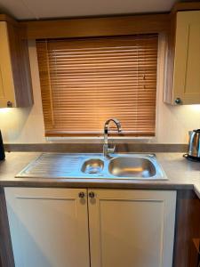 a kitchen counter with a sink and a window at Sandytoes and Seaside smiles in Wyke Regis