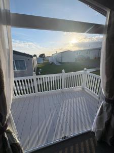 a balcony with a white fence and a white deck at Sandytoes and Seaside smiles in Wyke Regis
