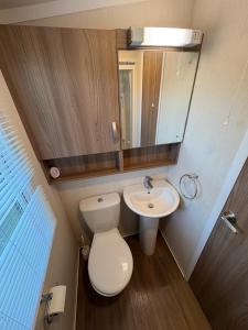a small bathroom with a toilet and a sink at Sandytoes and Seaside smiles in Wyke Regis +5 photos