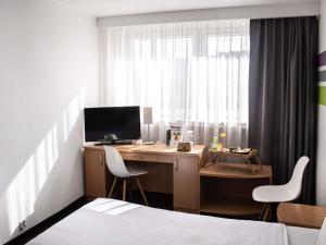 a bedroom with a desk with a computer and two chairs at ibis Styles Bielsko Biala in Bielsko-Biała
