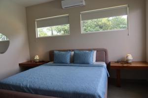 a bedroom with a blue bed with two windows at Casa Frank - Sophiassuites506 in Brasilito +71 photos