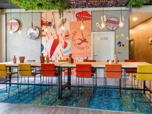 a room with a table and chairs and a clock at Ibis Madrid Getafe in Getafe