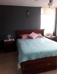 a bedroom with a bed with pink pillows on it at Alojamiento Rosales in San Antonio