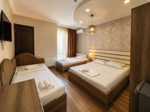 a hotel room with two beds and a table at Megobroba Hotel in Kobuleti