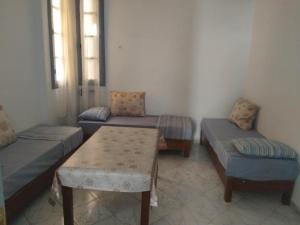 a living room with two couches and a table at مفروشة السعادة in Tlemcen