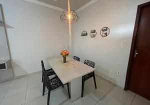 a dining room table with chairs and a vase of flowers on it at Dali Apart hotel in Ipatinga +17 photos