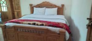 a bed with a wooden headboard in a room at Turgil Green Resort in Nomal