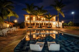 a resort with a swimming pool at night at Hotel Finca Buenos Aires Barichara in Barichara