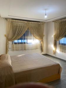 a bedroom with a large bed in front of a window at Appartement 3 in Al Hoceïma