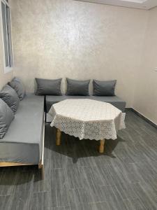 a couch with a table in a room at Appartement 3 in Al Hoceïma