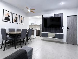 a dining room with a television and a table and chairs at Nice AptPoolBeach ClubParkingGymACBarraVieja in Barra Vieja