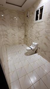 a bathroom with a toilet and a window at شاليهات تولين in Taif