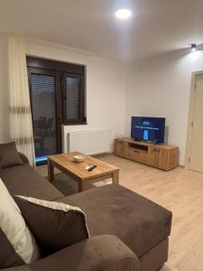 a living room with a couch and a tv at The Central Passage in Gornji Milanovac