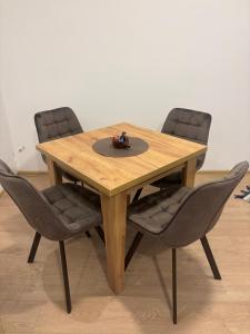 a wooden table with four chairs and a hat on it at The Central Passage in Gornji Milanovac