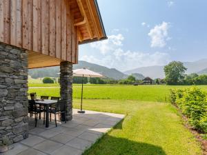 an outdoor patio with a table and an umbrella at Mountain Chalet Chapeau in Sankt Lorenzen ob Murau